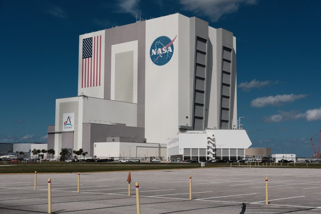 NASA control room monitors display satellite imagery and data feeds as analysts review unidentified aerial phenomena reports.